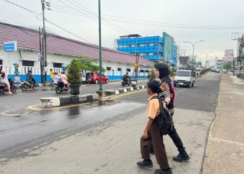 Wujud Nyata Polisi Humanis, Personel Polda Jambi Bantu Anak Sekolah Seberang Jalan di Jam Padat Pagi