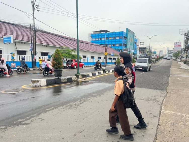 Wujud Nyata Polisi Humanis, Personel Polda Jambi Bantu Anak Sekolah Seberang Jalan di Jam Padat Pagi