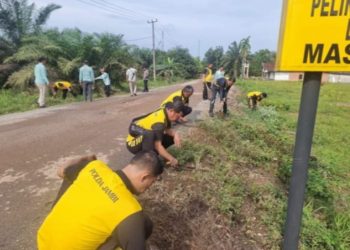 Polsek Maro Sebo Turun Pungut Sampah di Jalan Desa Jambi Kecil