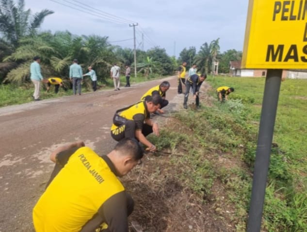 Polsek Maro Sebo Turun Pungut Sampah di Jalan Desa Jambi Kecil