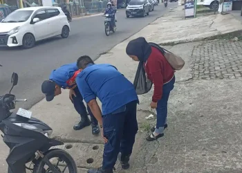 Damkartan Kota Jambi Bantu Warga Ambil Kunci Motor yang Jatuh ke Drainase
