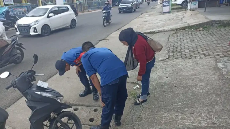 Damkartan Kota Jambi Bantu Warga Ambil Kunci Motor yang Jatuh ke Drainase