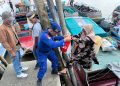Polisi Penolong Personel Satpolairud Polres Tanjab Barat Bantu Penumpang Turun Dari Kapal di Pelabuhan LLASDP Kuala Tungkal