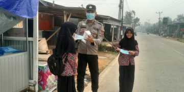 Cegah Dampak Kabut Asap, Polsek Pengabuan Bagikan Masker dan Imbau Pelajar Jaga Kesehatan